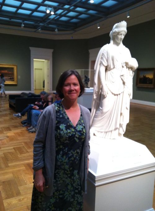 Photograph of Kate Culkin and a small model of Zenobia in Chains at the St. Louis Art Museum. 